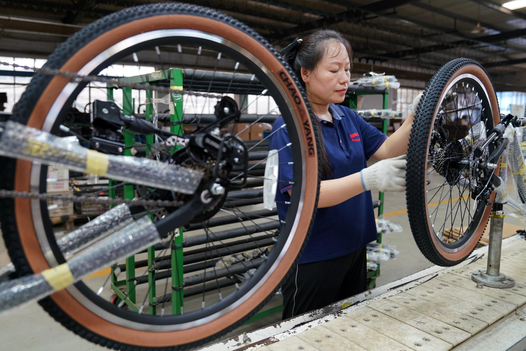 Worker assembling road bike wheels in a factory, representing capable manufacturers from the list of road bike manufacturers