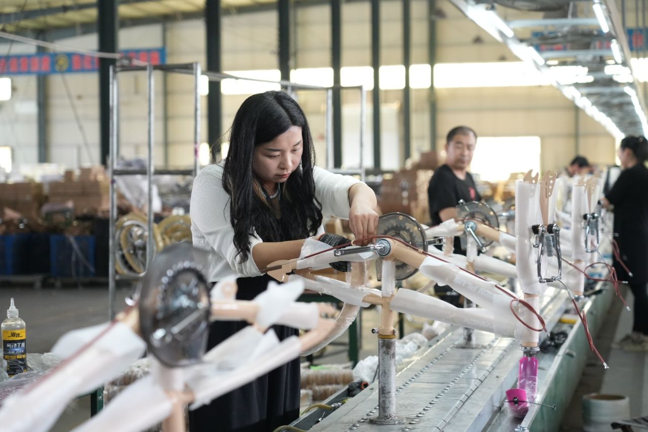 Worker installing road bike parts on the production line, showcasing manufacturers from the list of road bike manufacturers